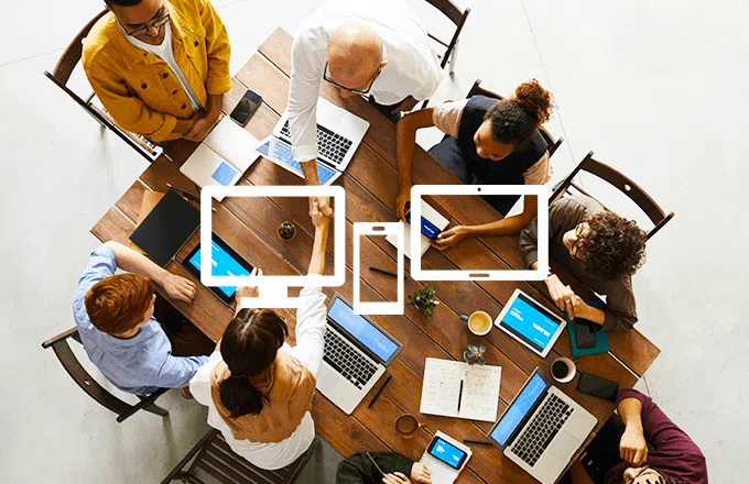 Group of people working at a table on laptops