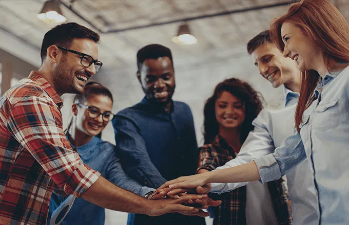 A group of people putting their hands together