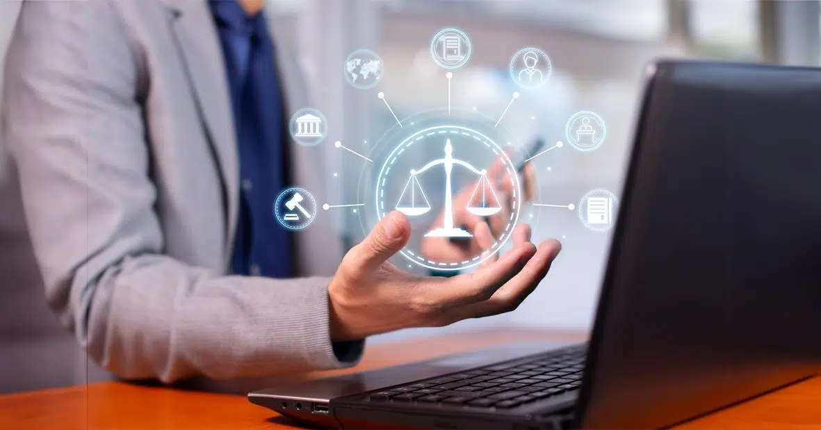 person sat at laptop with hand outstretched and digital icons representing AI and regulations overlaid