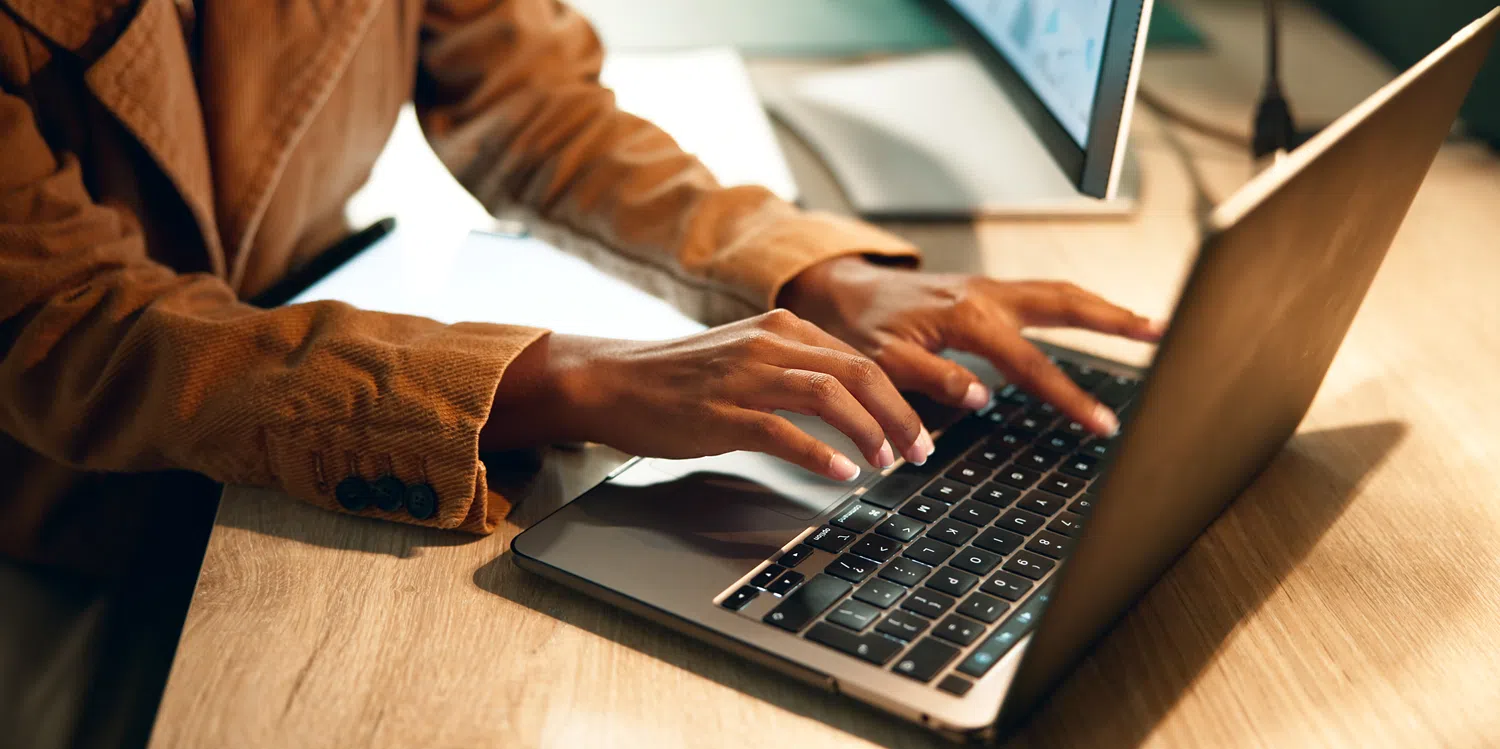 Professional using a laptop to develop applications and automate workflows, illustrating AI-powered low-code development and digital transformation.