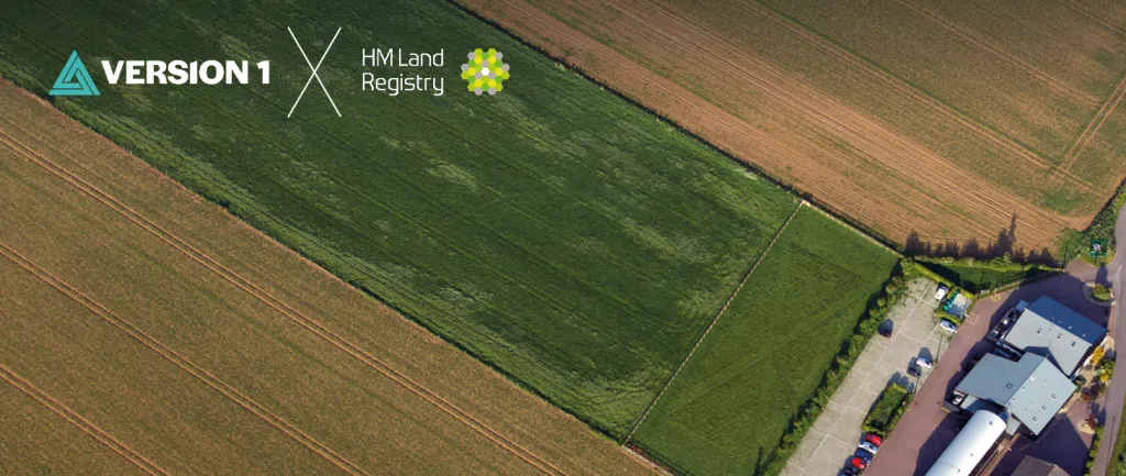 Promotional banner featuring Version 1 and HM Land Registry partnership, showing an aerial view of a suburban area beneath a blue sky. The image highlights HM Land Registry's data modernisation programme delivered in collaboration with Version 1.