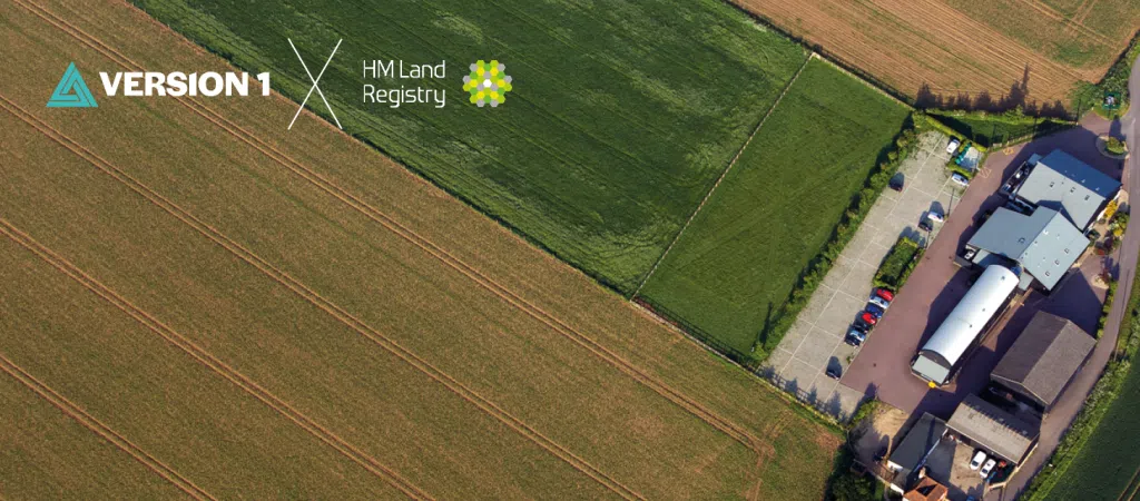 Promotional banner featuring Version 1 and HM Land Registry partnership, showing an aerial view of a suburban area beneath a blue sky. The image highlights HM Land Registry's data modernisation programme delivered in collaboration with Version 1.
