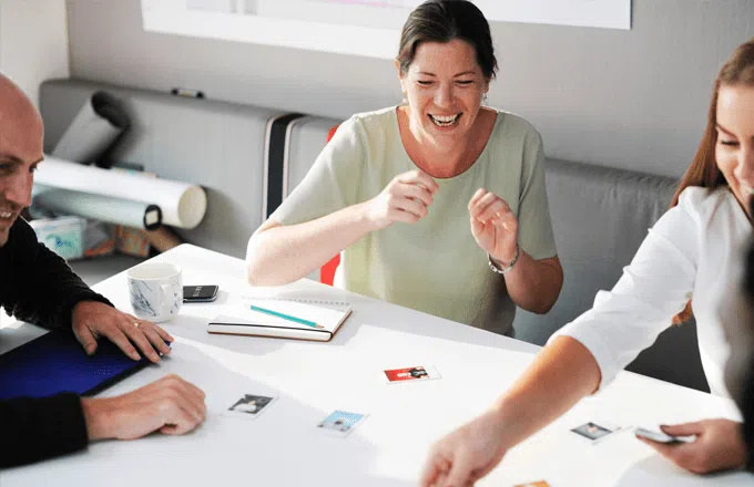 people looking at photographs on a table