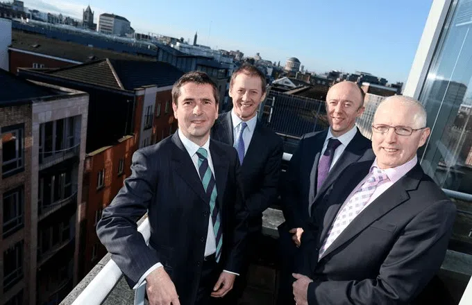 4 men in suits on a balcony