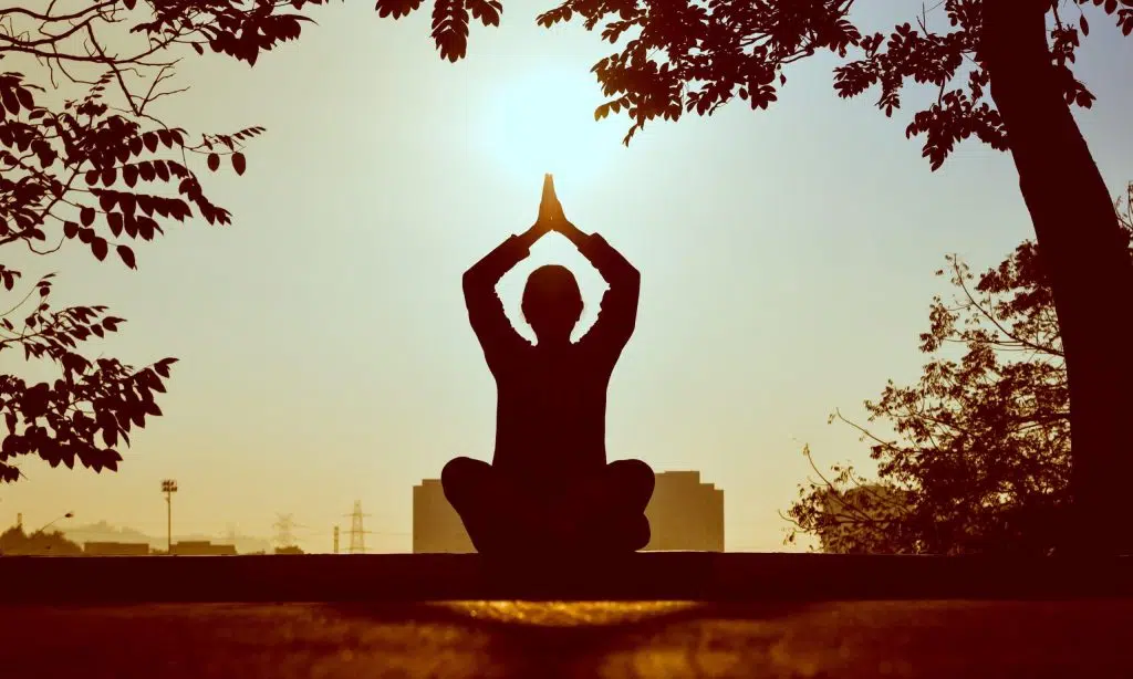 Silhouette of a person doing yoga outside