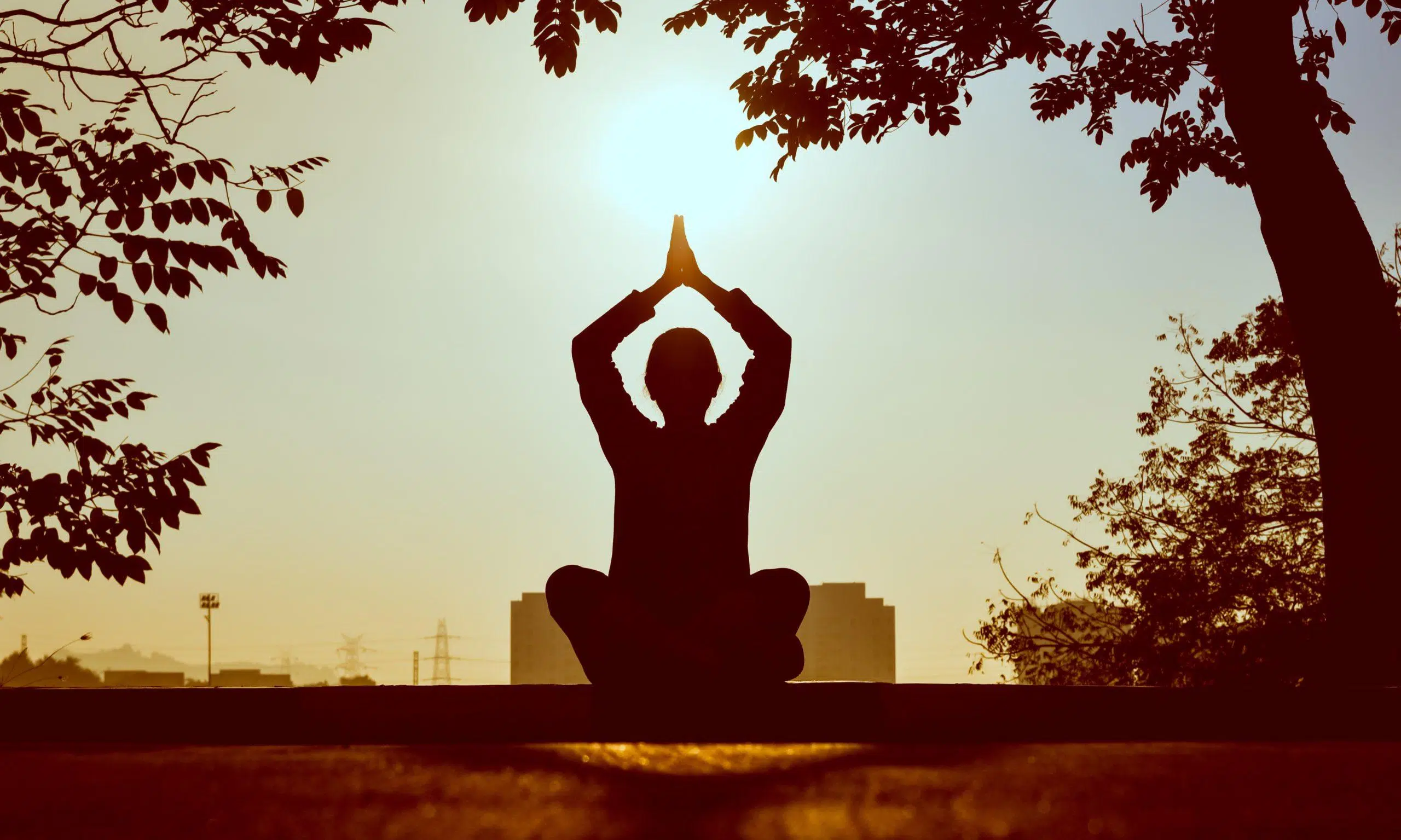 Silhouette of a person doing yoga outside