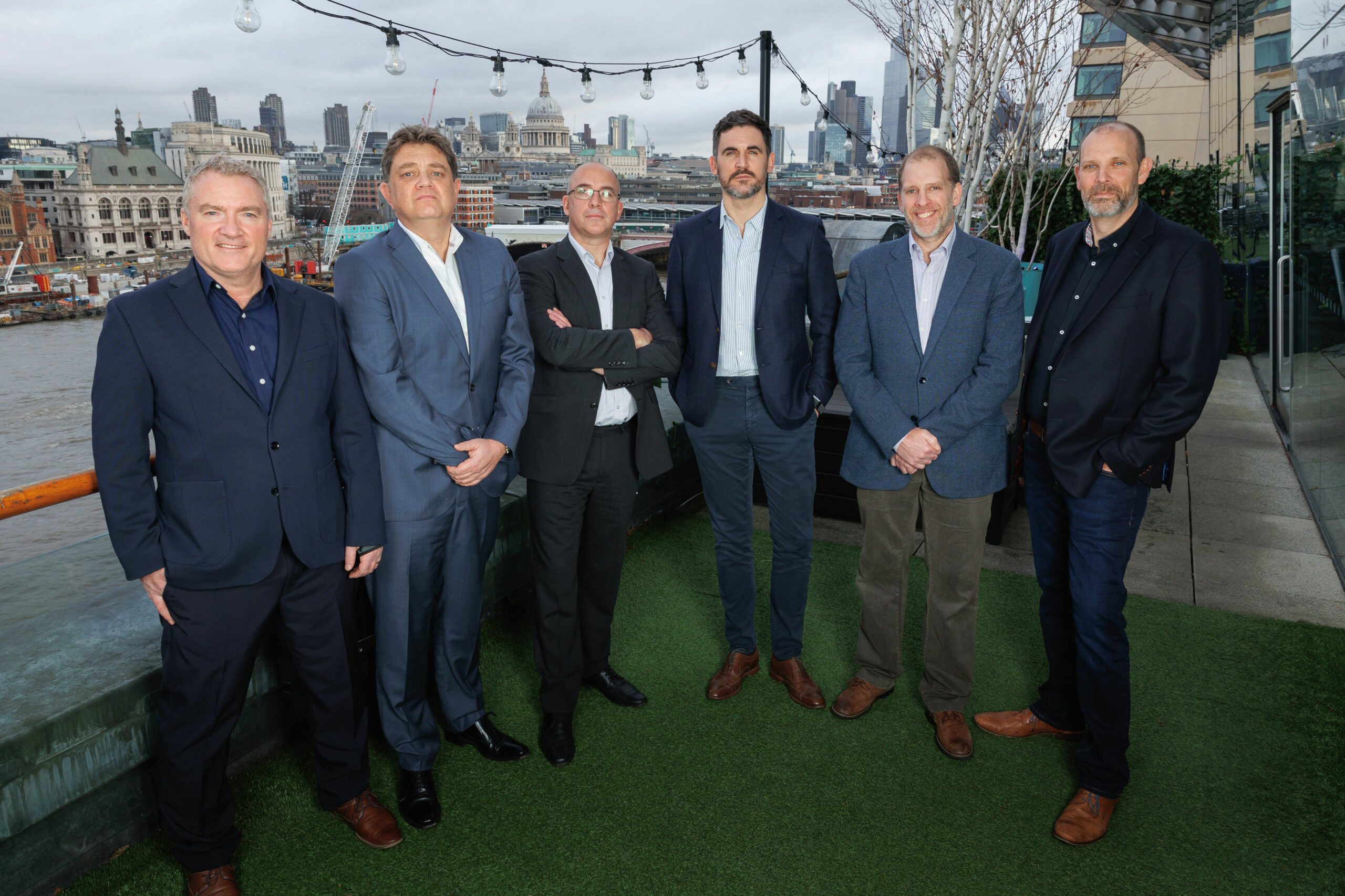 Qubix and Version 1 team members pictured on a balcony overlooking London city 
