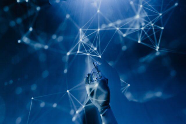 robotic hand pointing at some digital imagery in a Minority Report styling