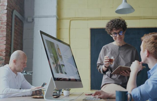 people talking at a desk in a modern office
