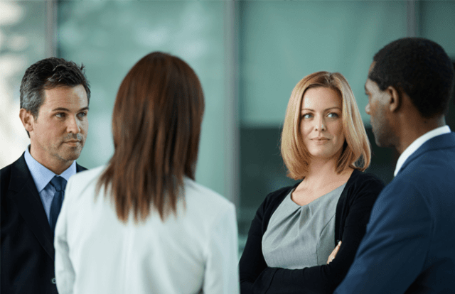 Four people dressed smartly stood talking