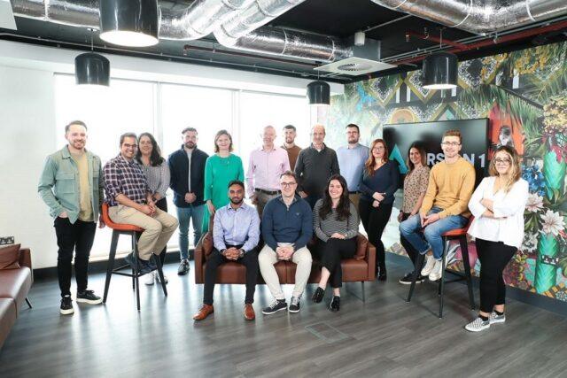 15 people in an office smiling