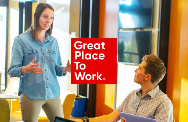 Great Place to Work logo laid over an image of a man and women speaking in an office