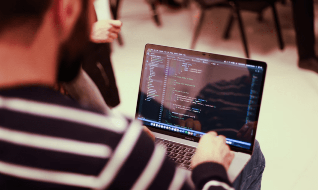 person coding on laptop