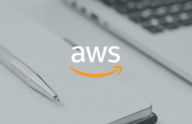 AWS logo over a notebook and pen