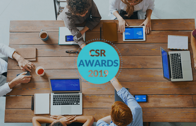 Birds eye view of a table with laptops and tablets and thhe CSR Awards logo