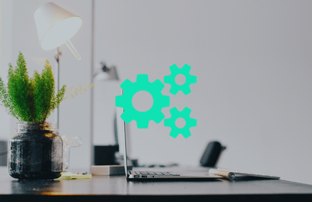 cogs icons over the top of an image of a desk and laptop