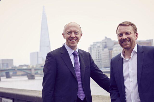Two men stood with a London skyline behind them