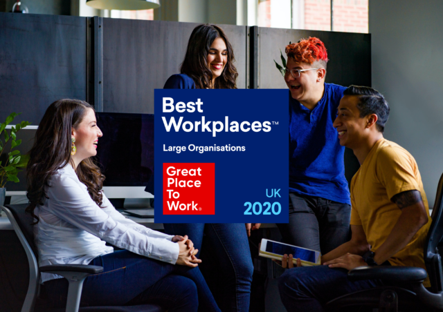 Great Place to Work logo laid over an image of four people talking in an office