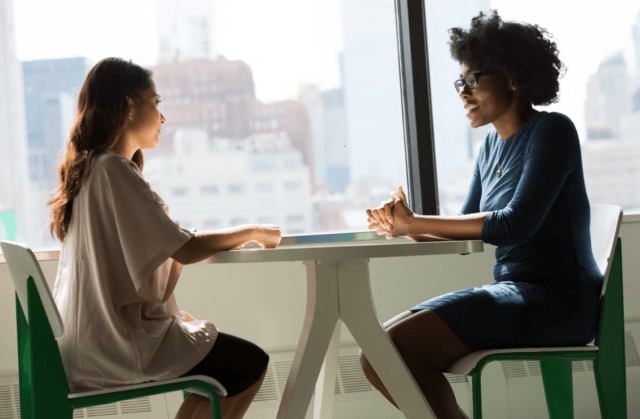 2 people sat at a table talking