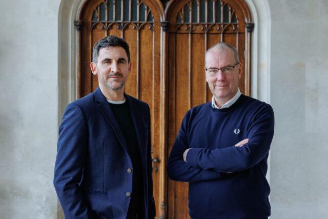 Two men stood outside some large doors