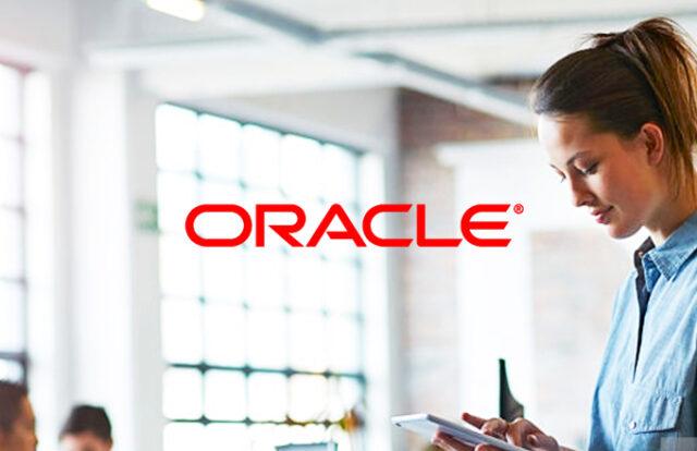 ORACLE logo laid over a woman using a tablet in an office