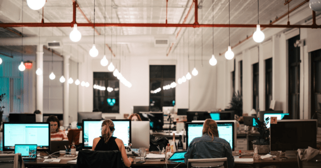 Group of people at desks using laptops