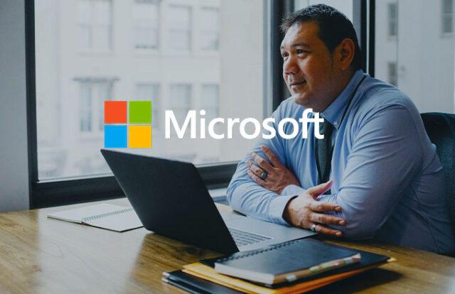 Man at a laptop with Microsoft logo