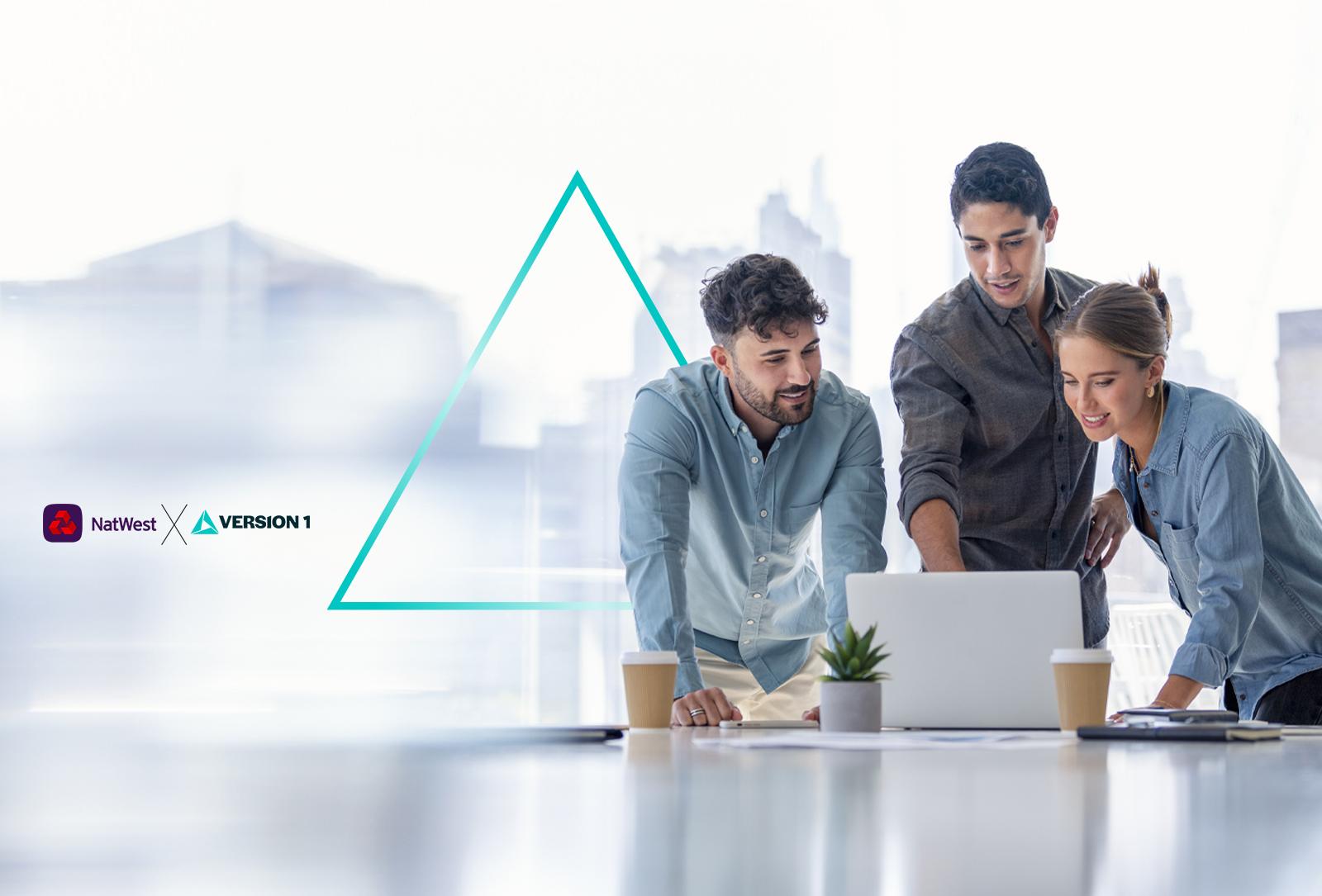 Three people around a laptop in an office