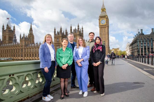 Group of people photographed with Big Ben in the background
