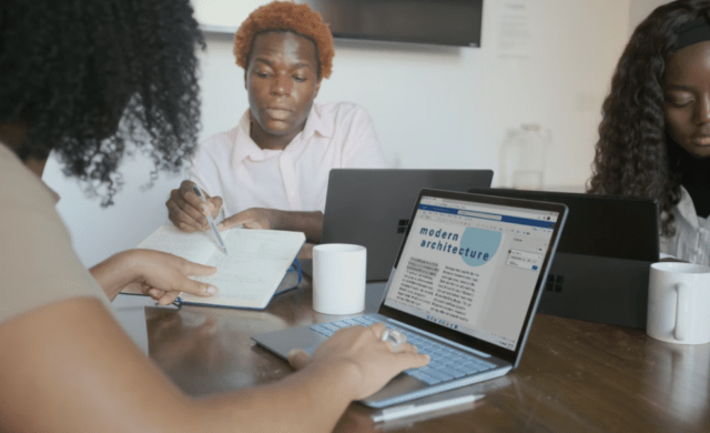 Three people using notebooks and laptops