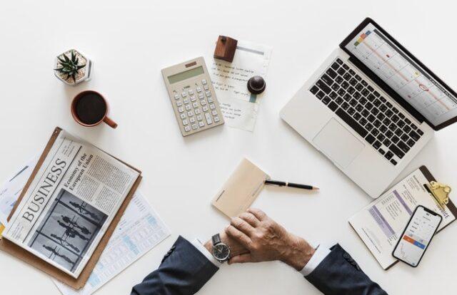 Laptop, calculator and newspaper