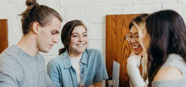 Four people around a laptop