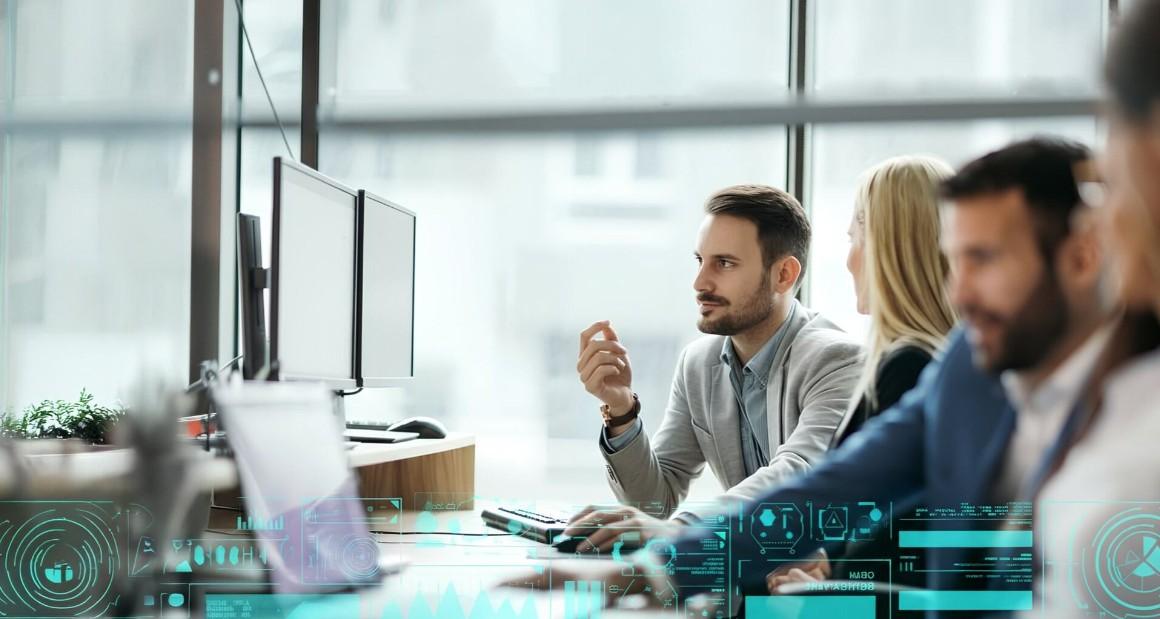 Professionals collaborating in a modern office, focused on computer screens with a digital AI-style data interface overlay in the foreground.