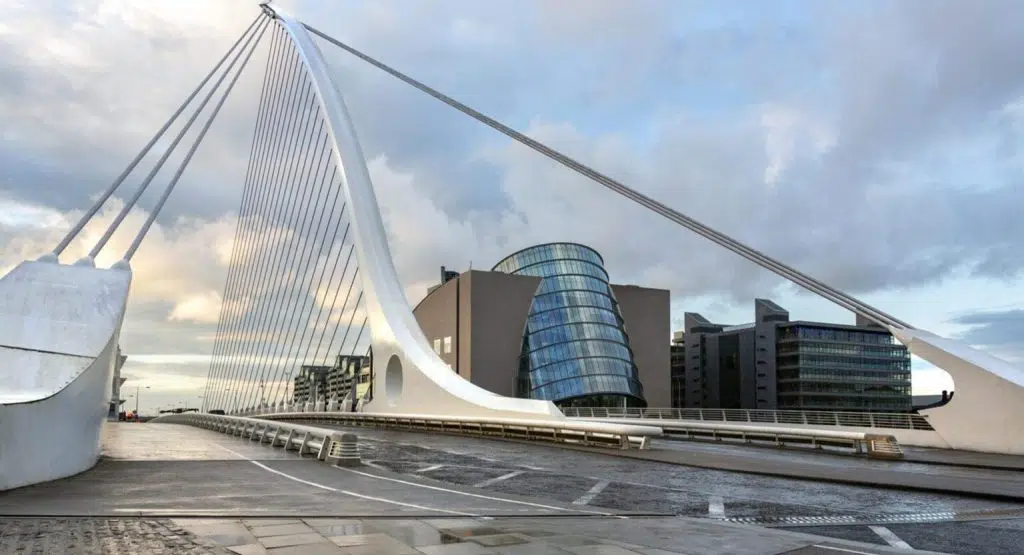 The Samuel Beckett Bridge and the building on the waterfront near the Convention Center - Dublin city center in the Republic of Ireland. This is a cable-stayed bridge that joins Sir John Rogerson's Quay on the south side of the River Liffey to Guild Street and North Wall Quay in the Docklands area. The innovative architect Santiago Calatrava designed this and a number of other bridges and buildings in Ireland.
